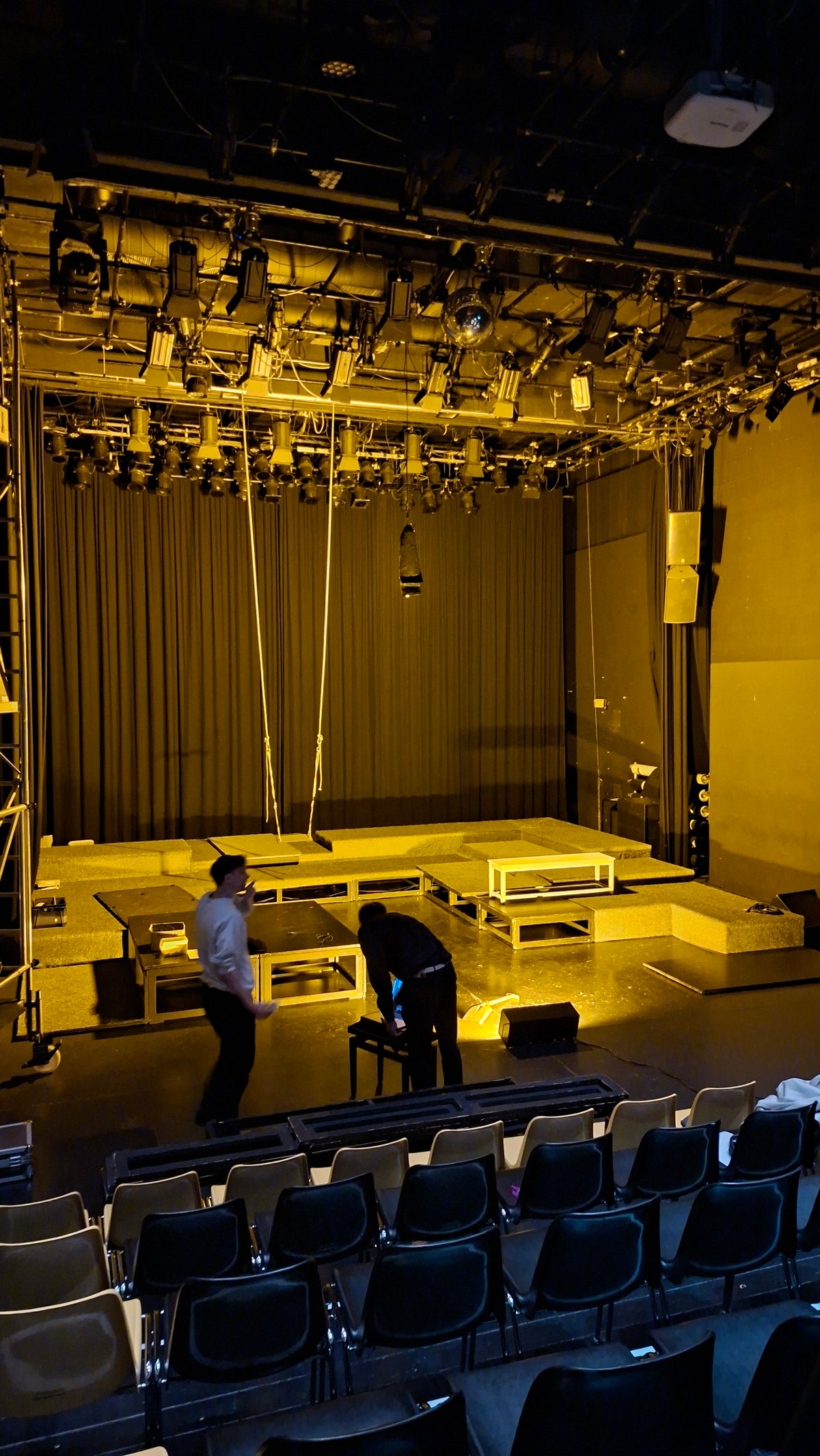 Stage lighting setup at Odeion Salzburg featuring warm monochromatic low-pressure sodium (SOX) lighting for theatrical performance.